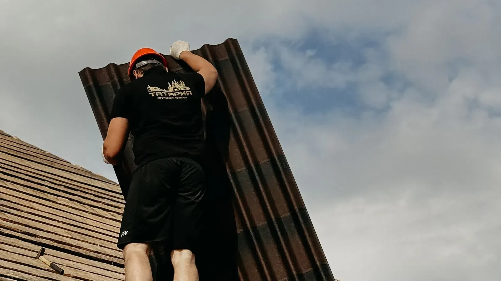 Roofers fitting new panels on a pitched roof